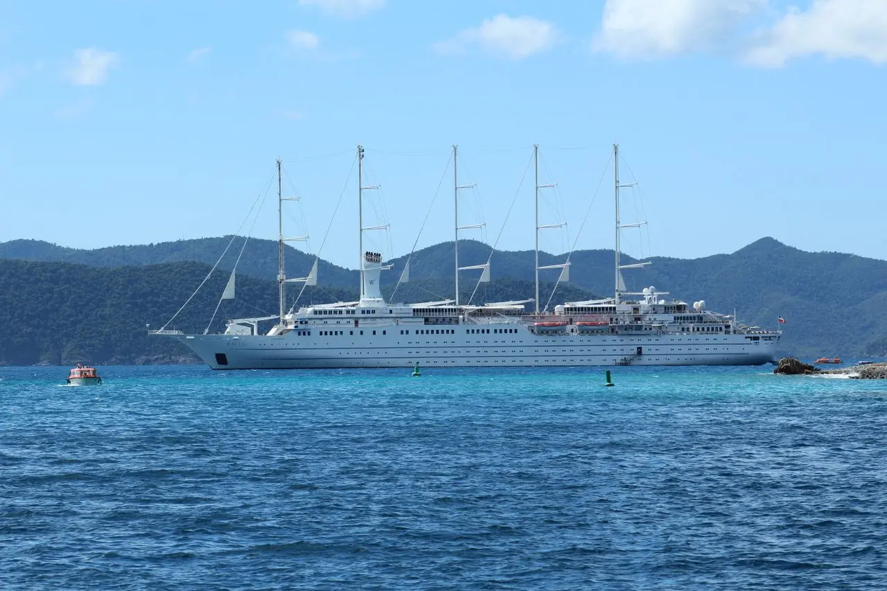 A large sailing vessel offshore beneath an open sky.