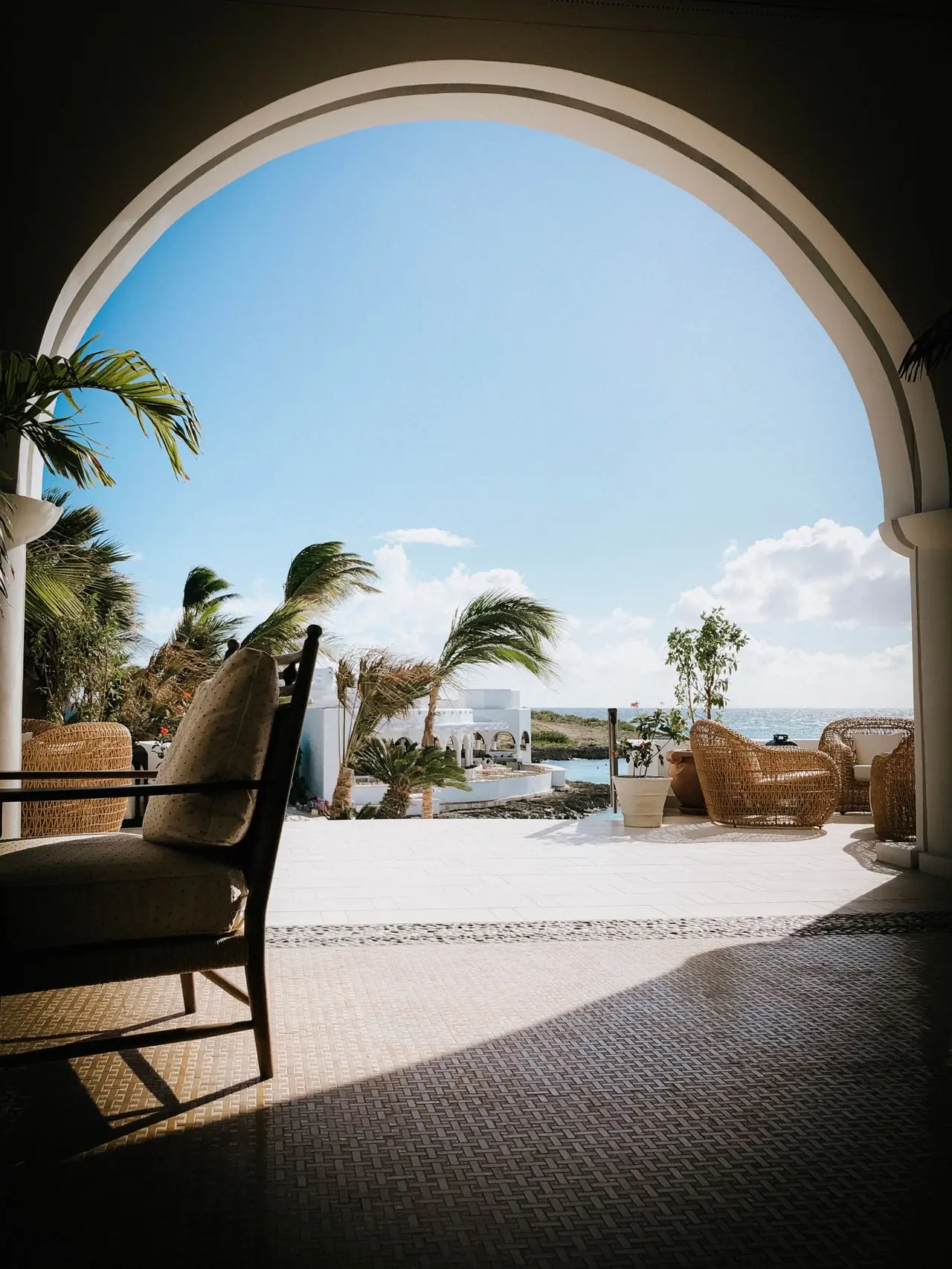 A shaded architectural arch framing the sea.
